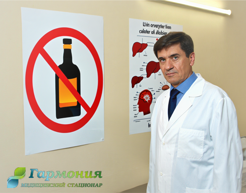 Врач стоит у стены с плакатами